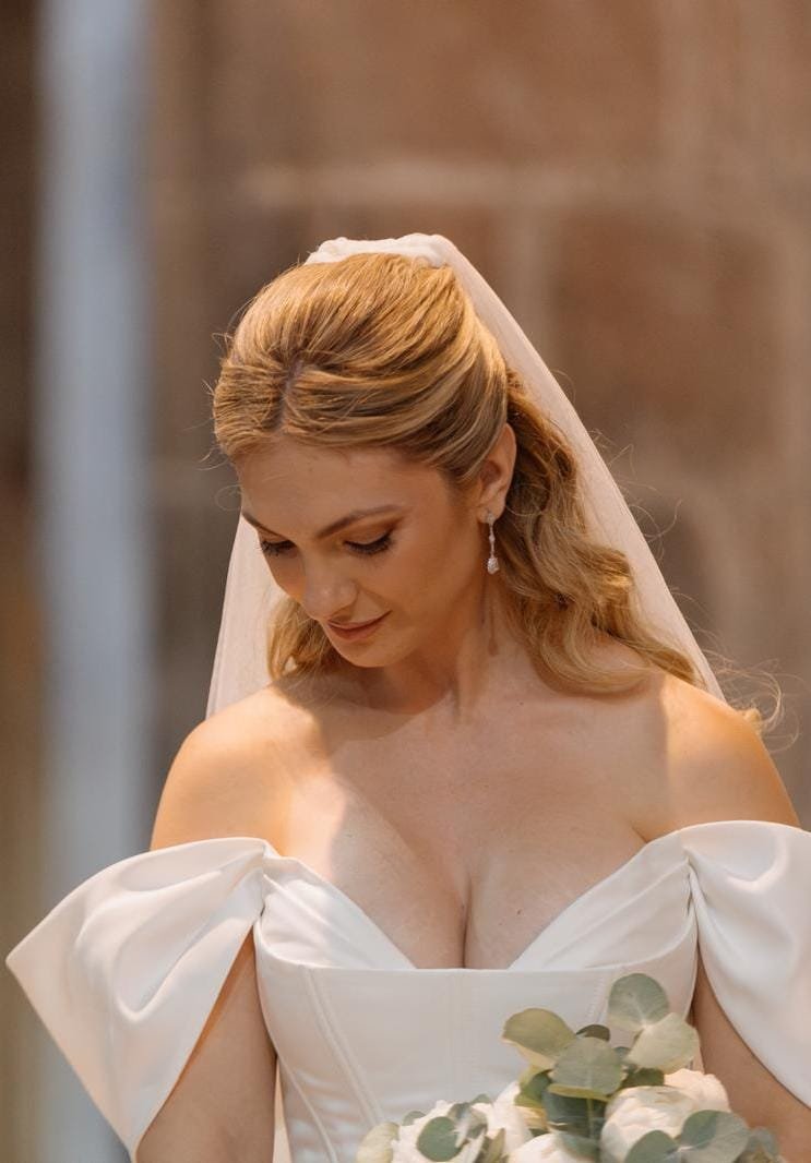 Novia con velo y vestido blanco sosteniendo un ramo